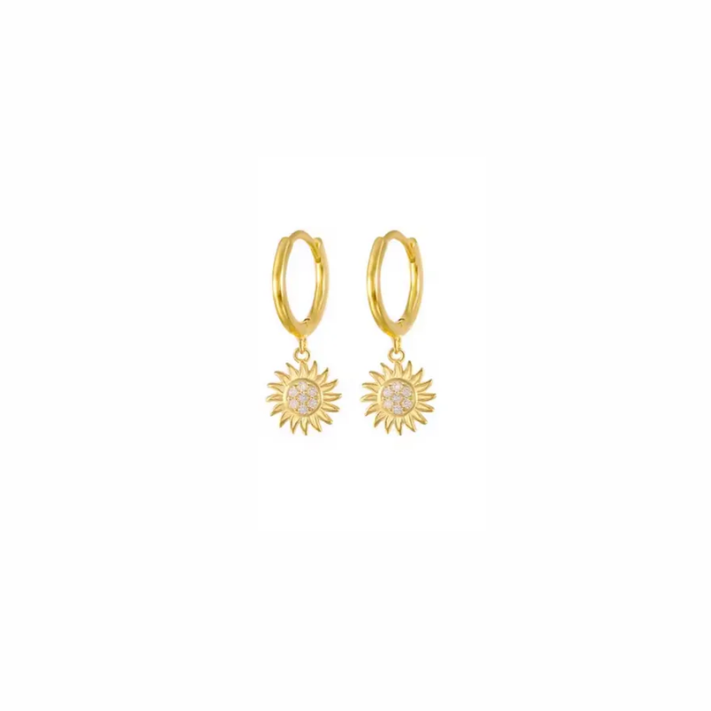 Gold Sunburst huggie hoop earrings worn on ear, glowing in sunlight