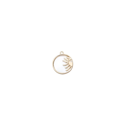 Gold circular sun charm with a crystal detail on a white background