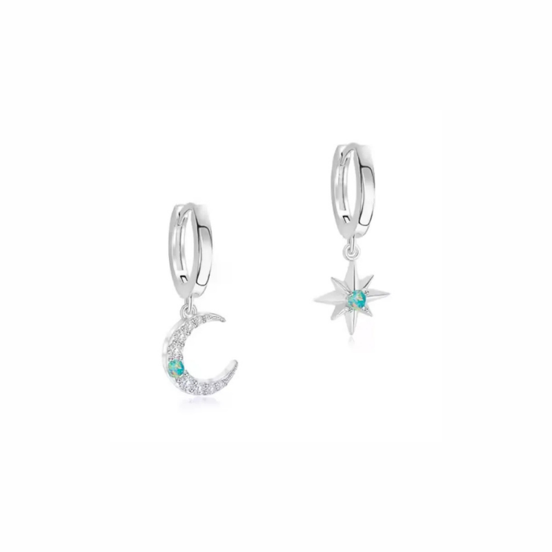 Siren sterling silver moon and star huggie earrings worn on ear, delicate celestial look