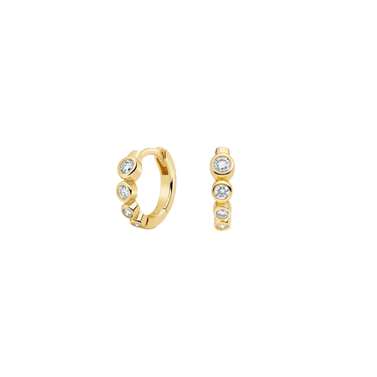 Gold crystal huggie hoop earrings worn on ear, minimalist jewellery
